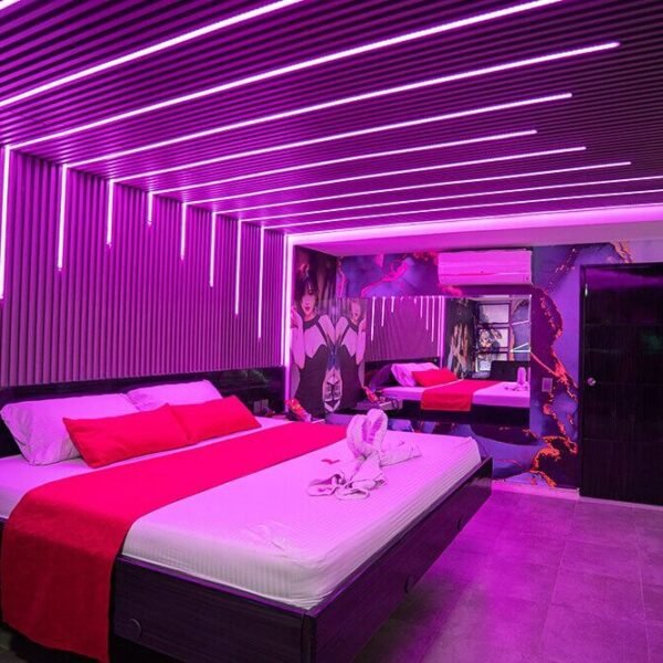 Vibrante habitación de motel con luces LED púrpura y arte mural urbano iluminando el espacio moderno.