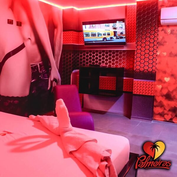 El logotipo de Palmeiras marca una habitación en sombras bañada por un brillo carmesí, que adorna un gran mural, un televisor y una ingeniosa exhibición de toallas sobre la cama.