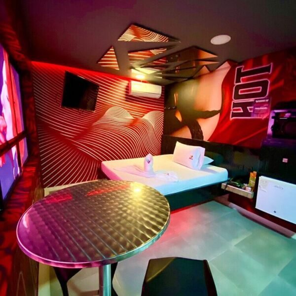 Habitación de motel que presenta una decoración moderna, adornada con un diseño geométrico en las paredes y muebles elegantes.