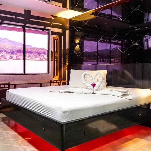 Contemporáneo cuarto de motel con una cama amplia, vistas panorámicas a un lago sereno desde las ventanas y un jacuzzi relajante.