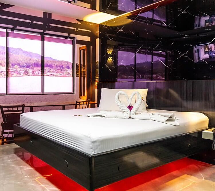 Contemporáneo cuarto de motel con una cama amplia, vistas panorámicas a un lago sereno desde las ventanas y un jacuzzi relajante.