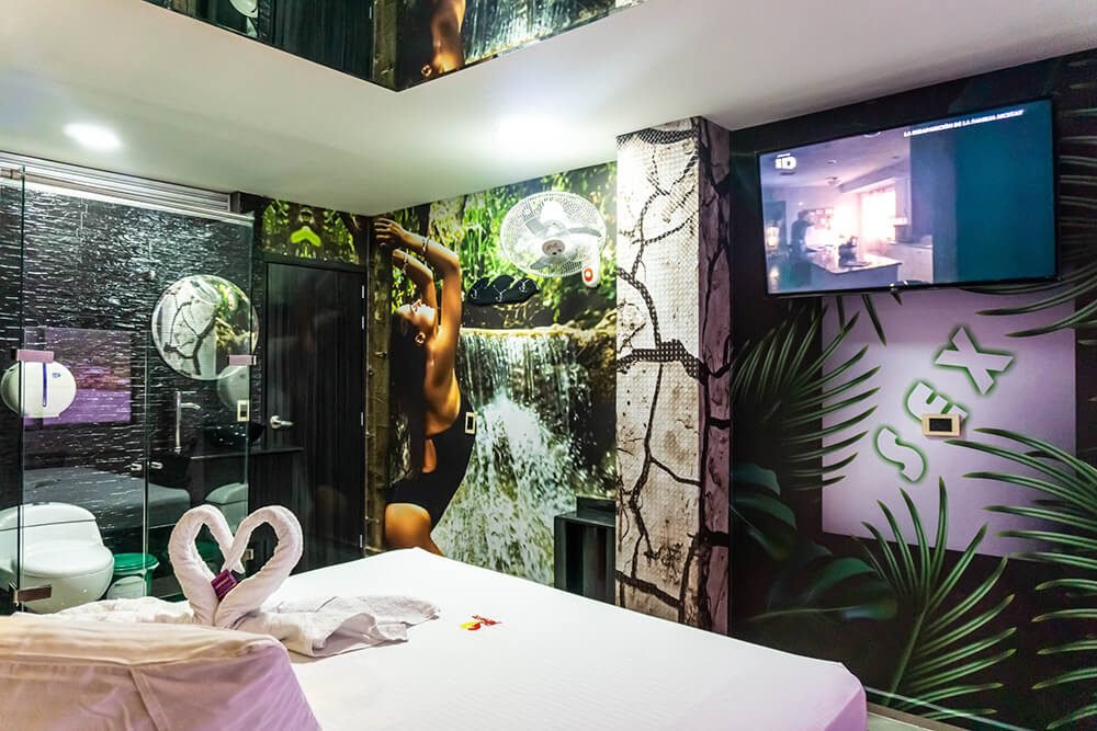 Suite de motel moderna y elegante con toques artísticos, un elegante televisor de pantalla plana y un acogedor jacuzzi.