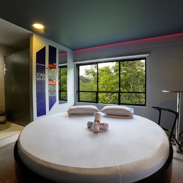 Un mote clásico pero minimalista, con una cama redonda cómoda y una ventana que marco la abundancia de follaje exterior.